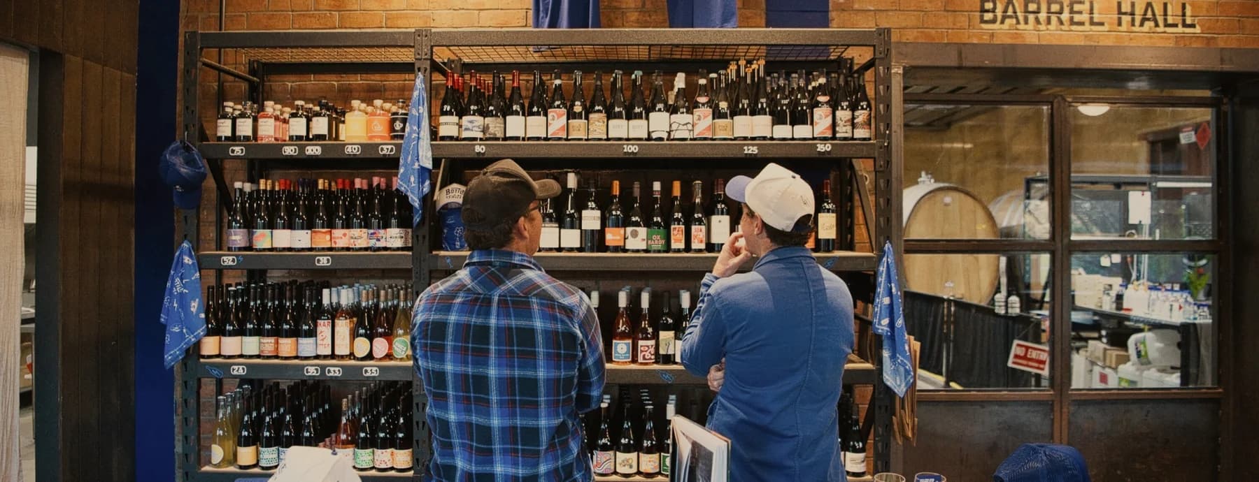 Two guests choosing from the wine wall by the Barrel Hall at Bottle Shock, Gumeracha