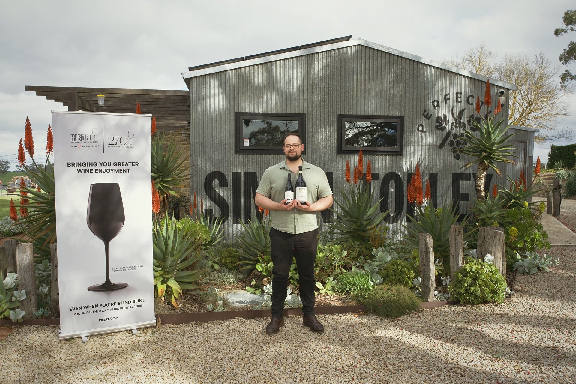 The Adelaide Hills Cup champion holds two bottles in front of the Simon Tolley shed.