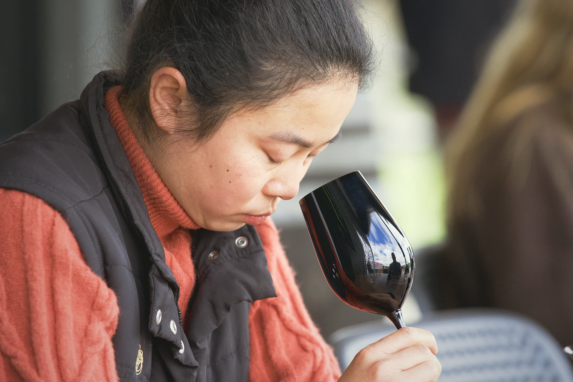 A competitor nose-deep in a black glass, eyes closed, mid-call.